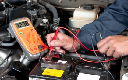 Garagiste qui vérifie la tension d'une batterie de véhicule