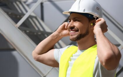 Homme sur chantier qui se protège les oreilles avec des bouchons d'oreilles
