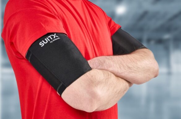 Personne portant des brassards d’exosquelette SUITX by Ottobock sur les bras, conçus pour le soutien musculaire lors d’activités professionnelles.