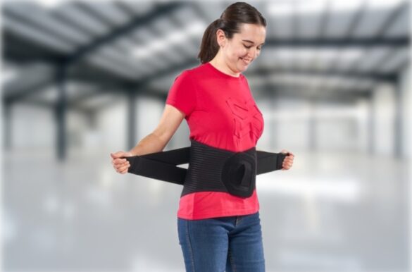 Personne ajustant une ceinture dorsale d’exosquelette pour le soutien lombaire, dans un environnement industriel ou logistique.