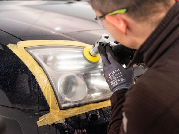 Technicien utilisant une ponceuse orbitale Würth pour le polissage d’un phare automobile durant une rénovation professionnelle